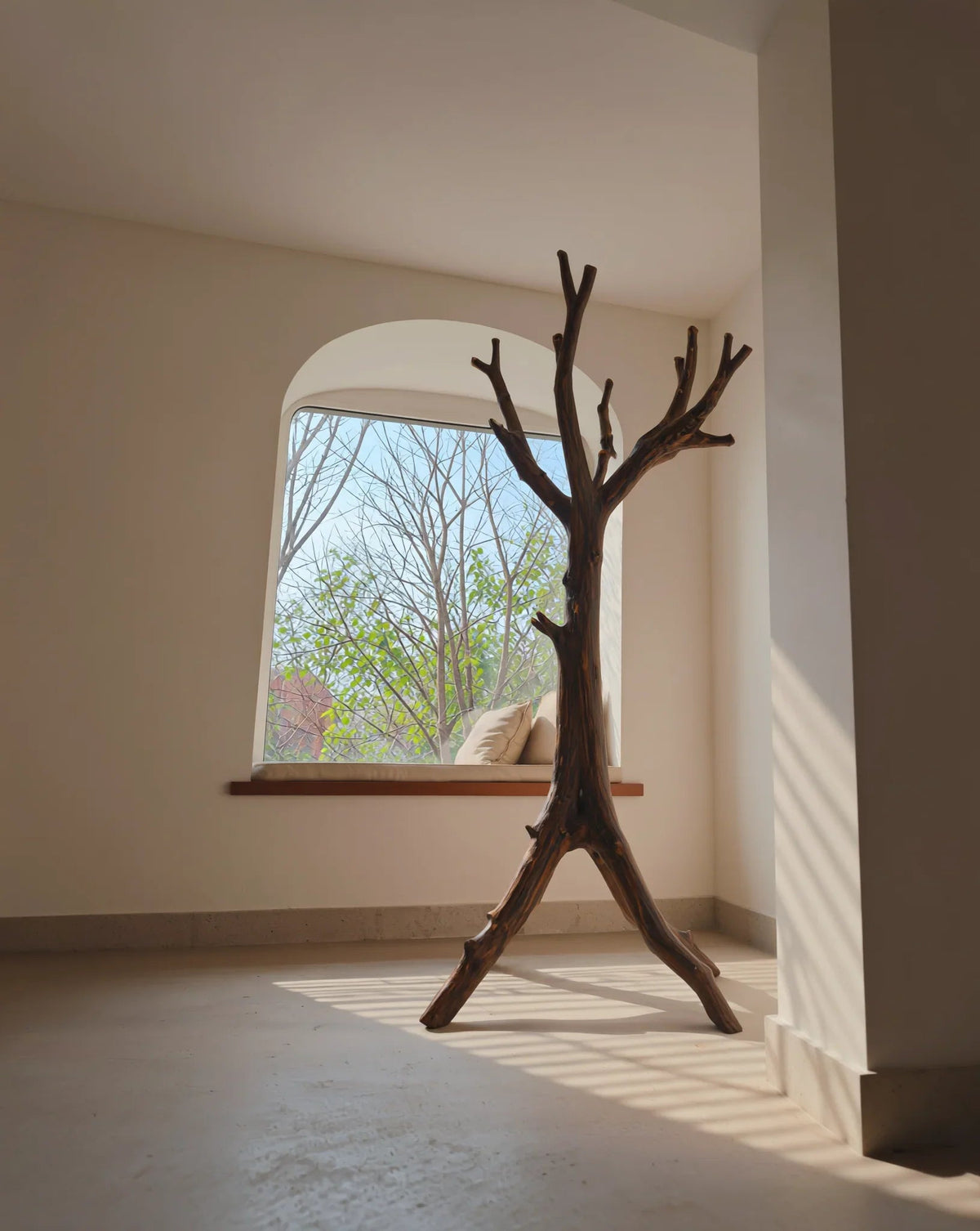 Duurzaam gemaakte houten boomkapstok in lichte minimalistische kamer bij het raam
