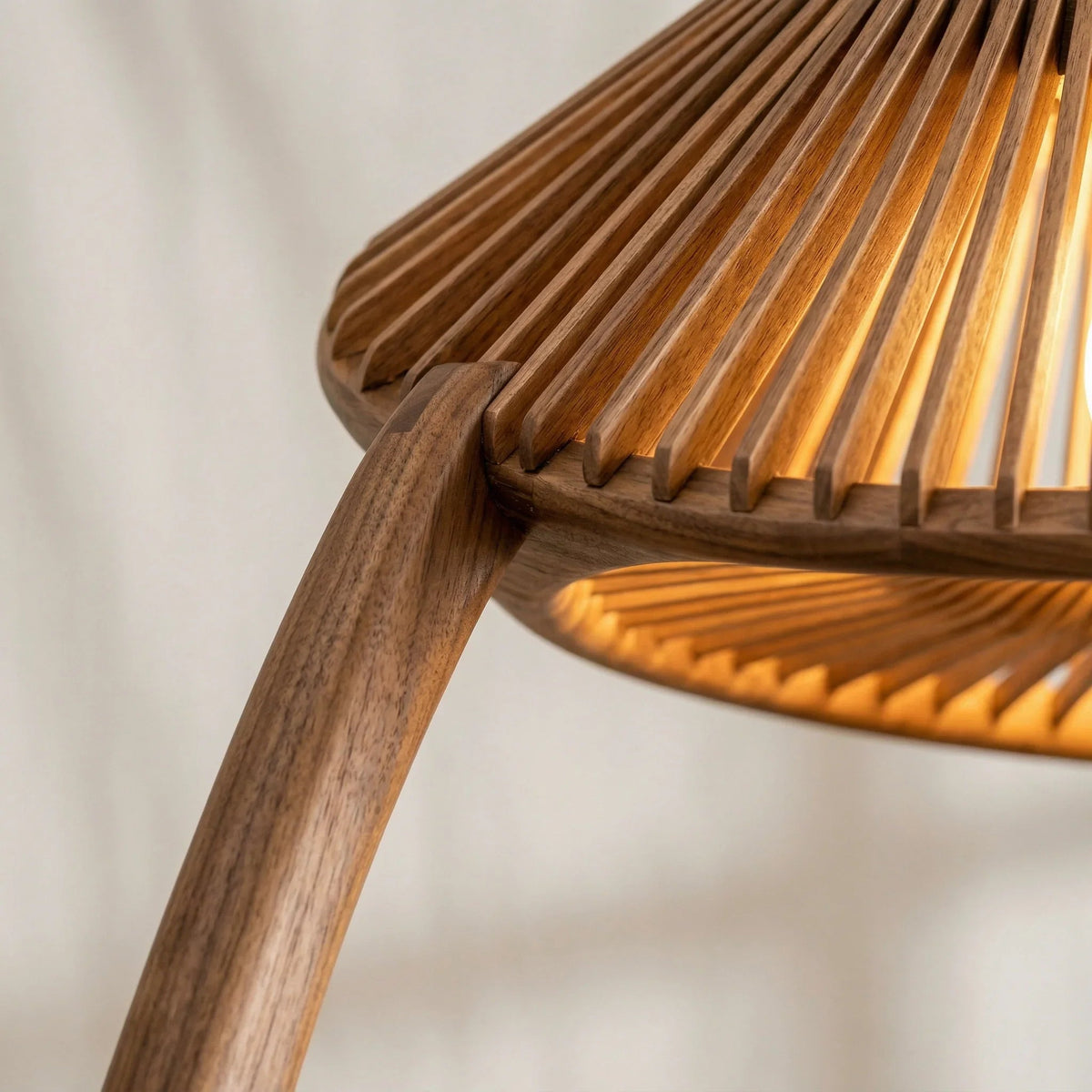 Close-up of handcrafted wood arc floor lamp with slatted dome shade, warm light glowing.
