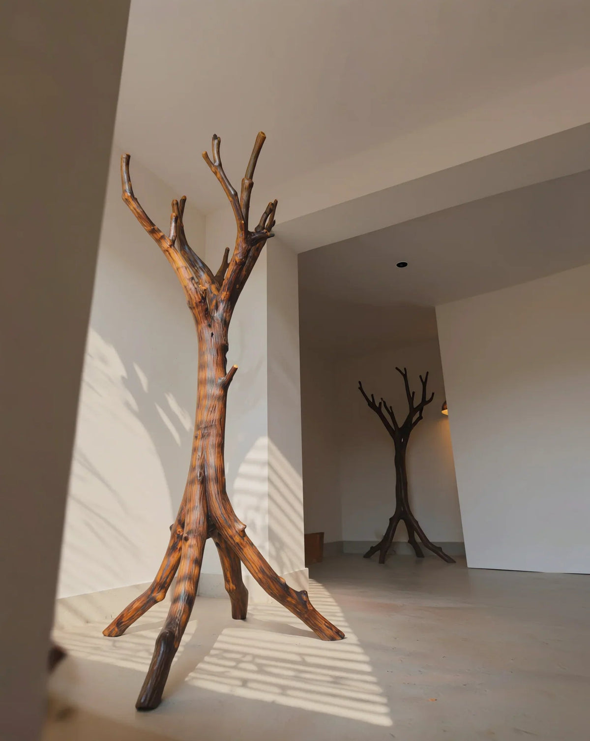 Sculpturale houten kledingstandaard in moderne hal