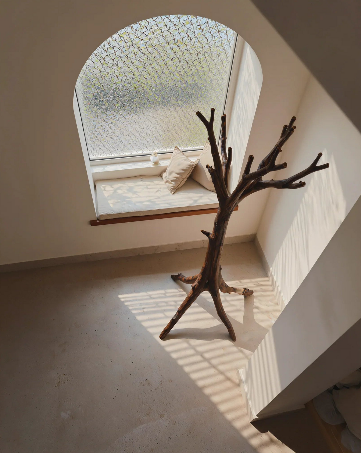 Houten kledingstandaard in minimalistisch interieur naast raam
